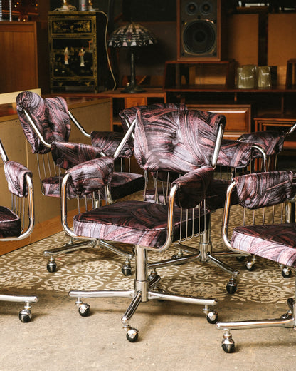 Side view of chrome swivel armchairs clustered together showing tufted backs and casters