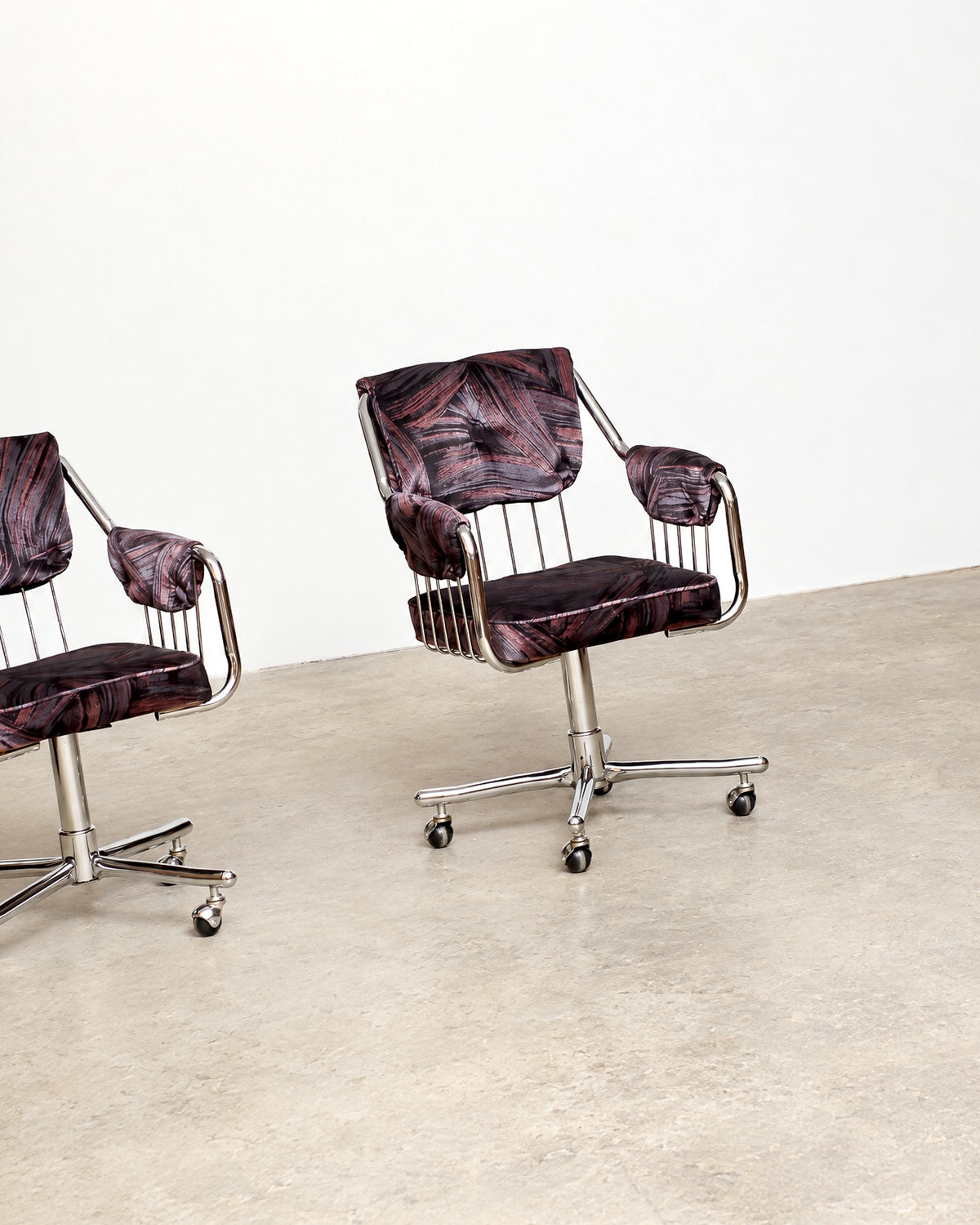 Side profile of chrome swivel armchair highlighting the tubular frame and wire seat back