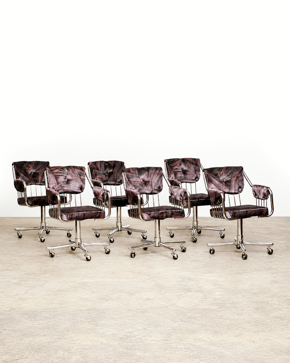Close-up of chair base showing chrome cross legs and rolling casters