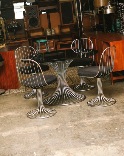 Full view of the chrome Tulip "Margot" dining set with oval glass top and four swivel chairs.