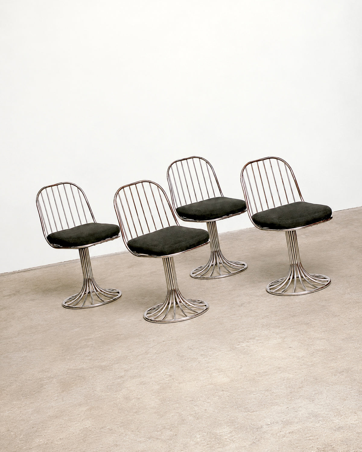 Close-up of the table's pedestal base showing the tubular chrome construction.