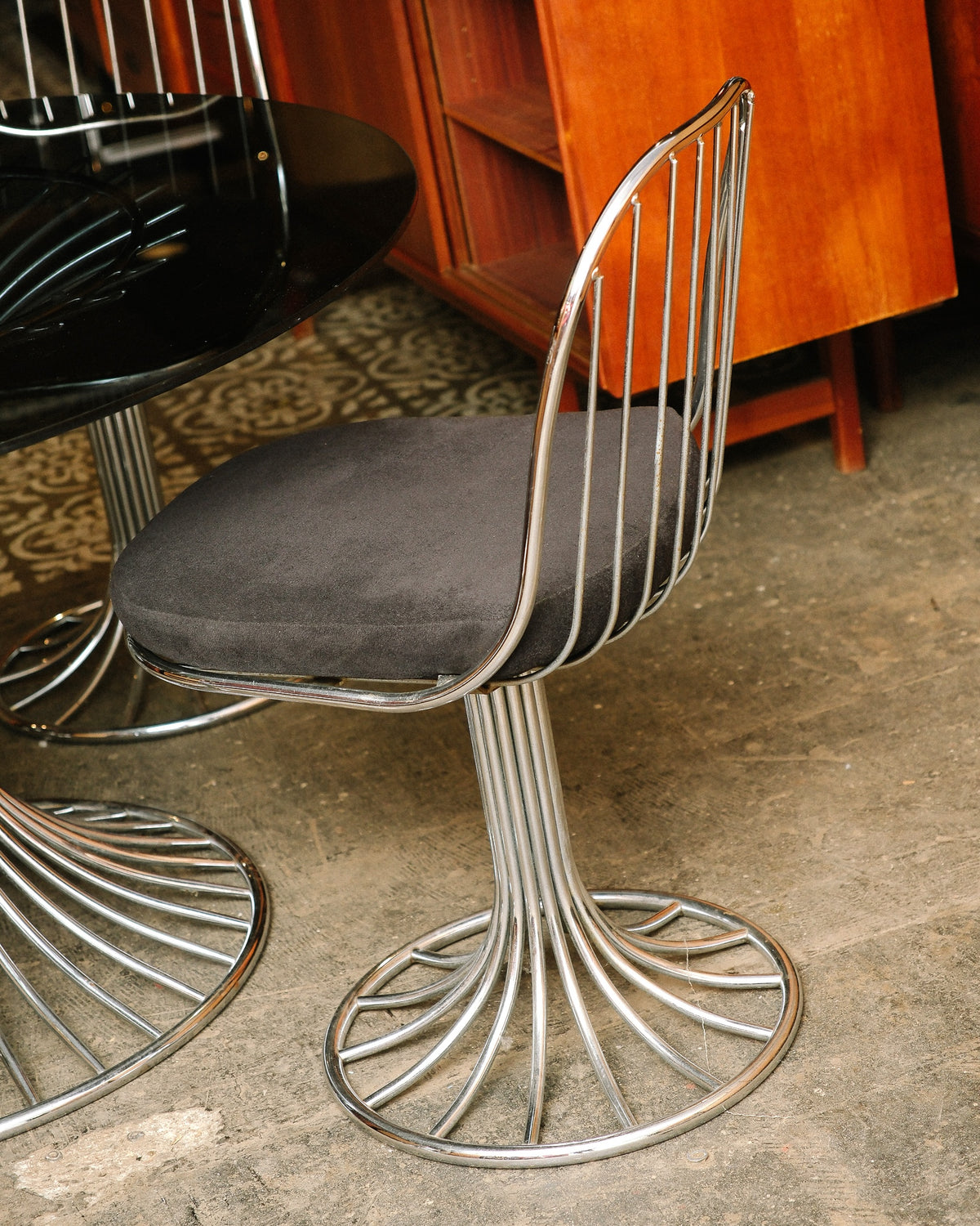 Side view of a single swivel chair showing the wire spindle back and upholstered seat.