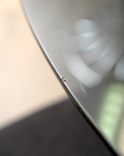 Close-up of a small chip on the edge of the glass table top.
