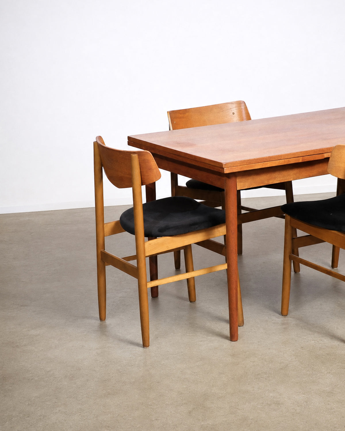 Wide shot of the full dining set in the showroom with other vintage furniture visible.