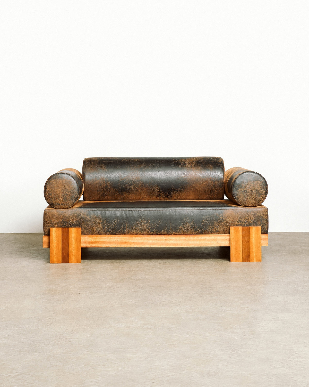 Additional angle of the distressed leather sofa showing the wood base and leather texture.