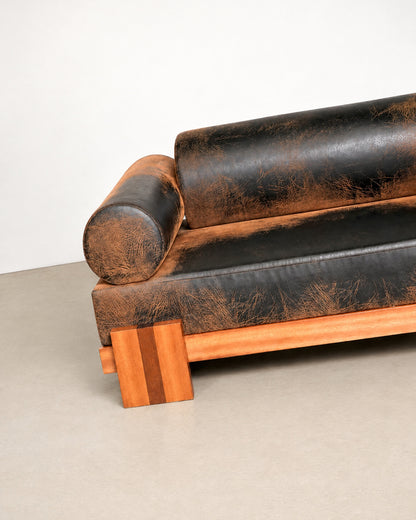 Side profile of the distressed leather sofa highlighting its low platform silhouette.