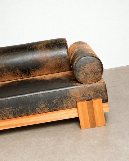 Wide view of the distressed leather sofa within the showroom, showing scale and proportions.