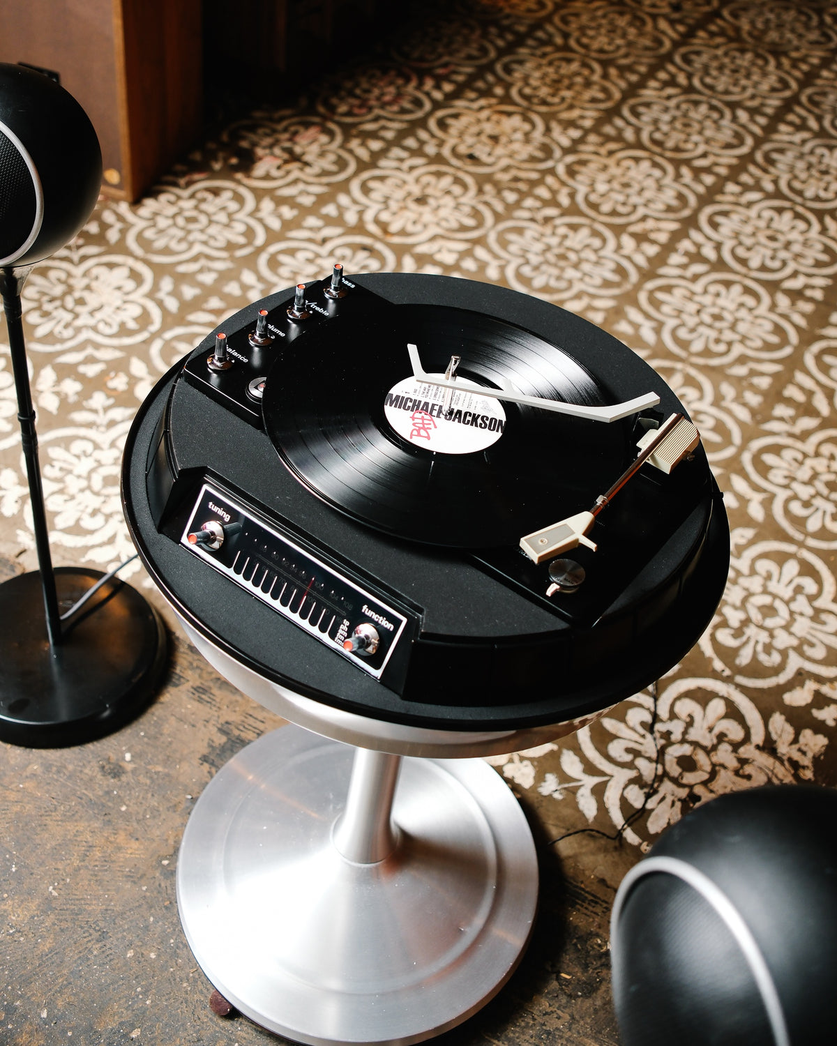 High angle view of the turntable spinning a record, with tuning and function controls visible on the console.