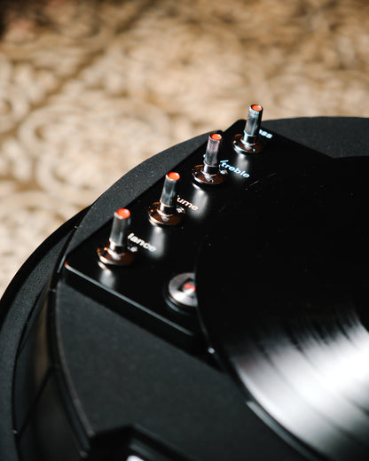 Detail of the volume, balance, treble, and bass knobs on the console edge.