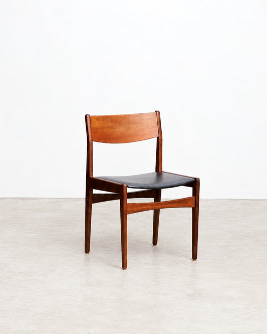 Additional angle of the teak dining chair highlighting the wood grain and black vinyl seat.