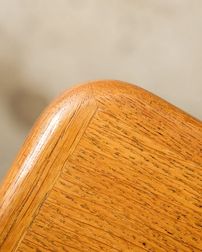 Close-up of the oak table's edge and mitred corner joinery, showing wood grain.