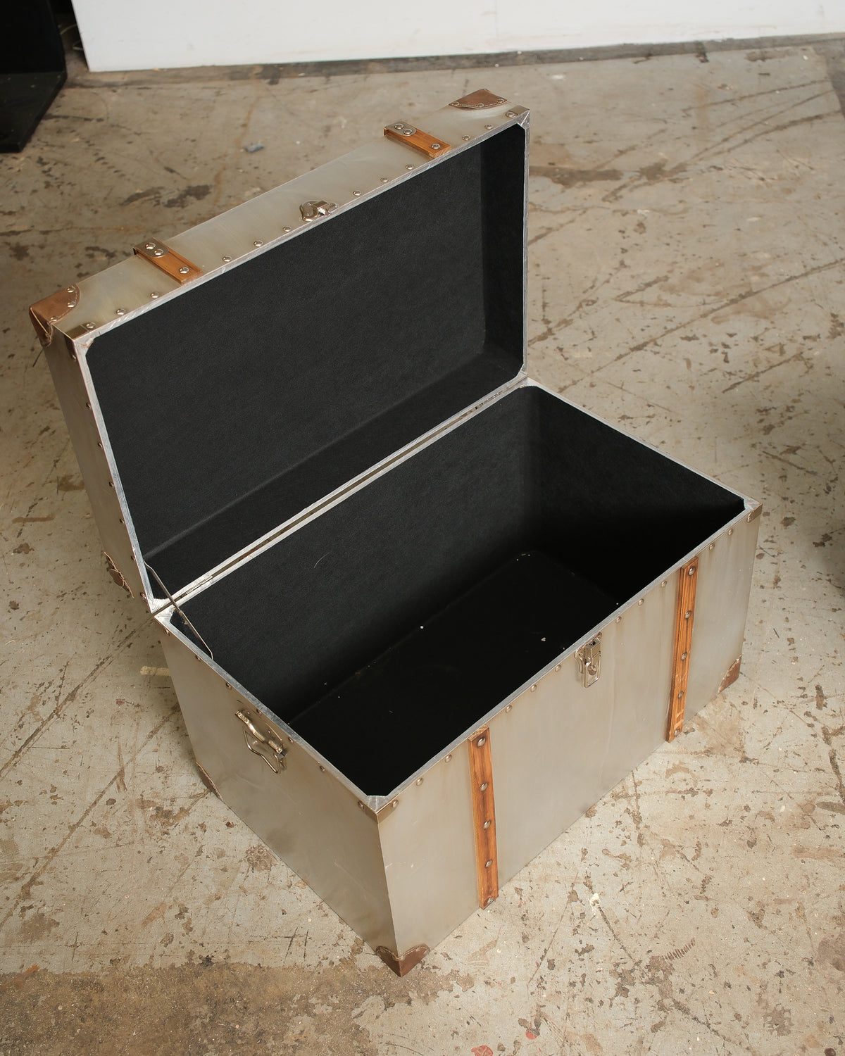 Large trunk open, showing the black lined interior and hinged lid construction.