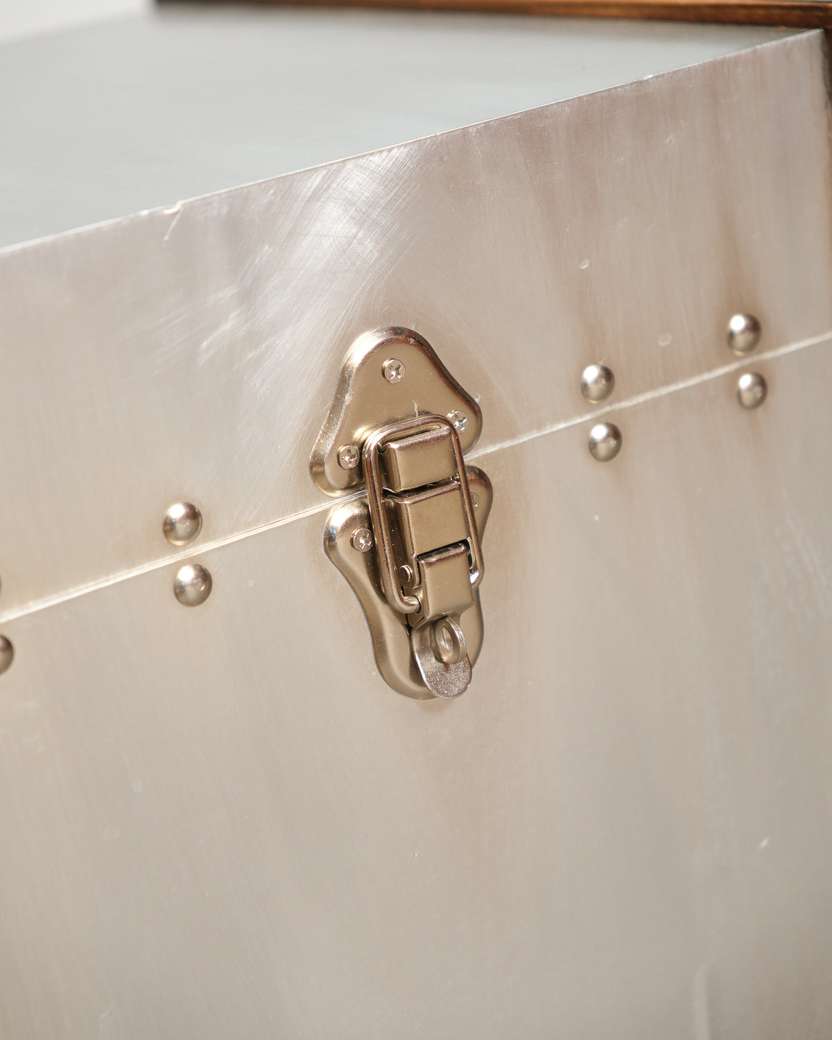 Close-up of the nickel-finish latch hardware and rivet detail on the trunk exterior.