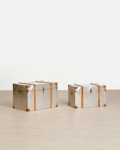 Side profile of the trunk showing the side handle and metal cladding finish.