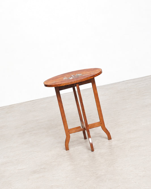 Side table photographed against a plain background, showing its full profile, legs, and stretcher construction.