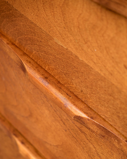 Close-up of a drawer front showing wood grain and a small surface ding.