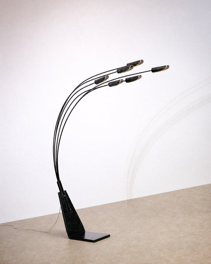 Full side view of the black 6-light floor lamp showing its curved arms and triangular base.