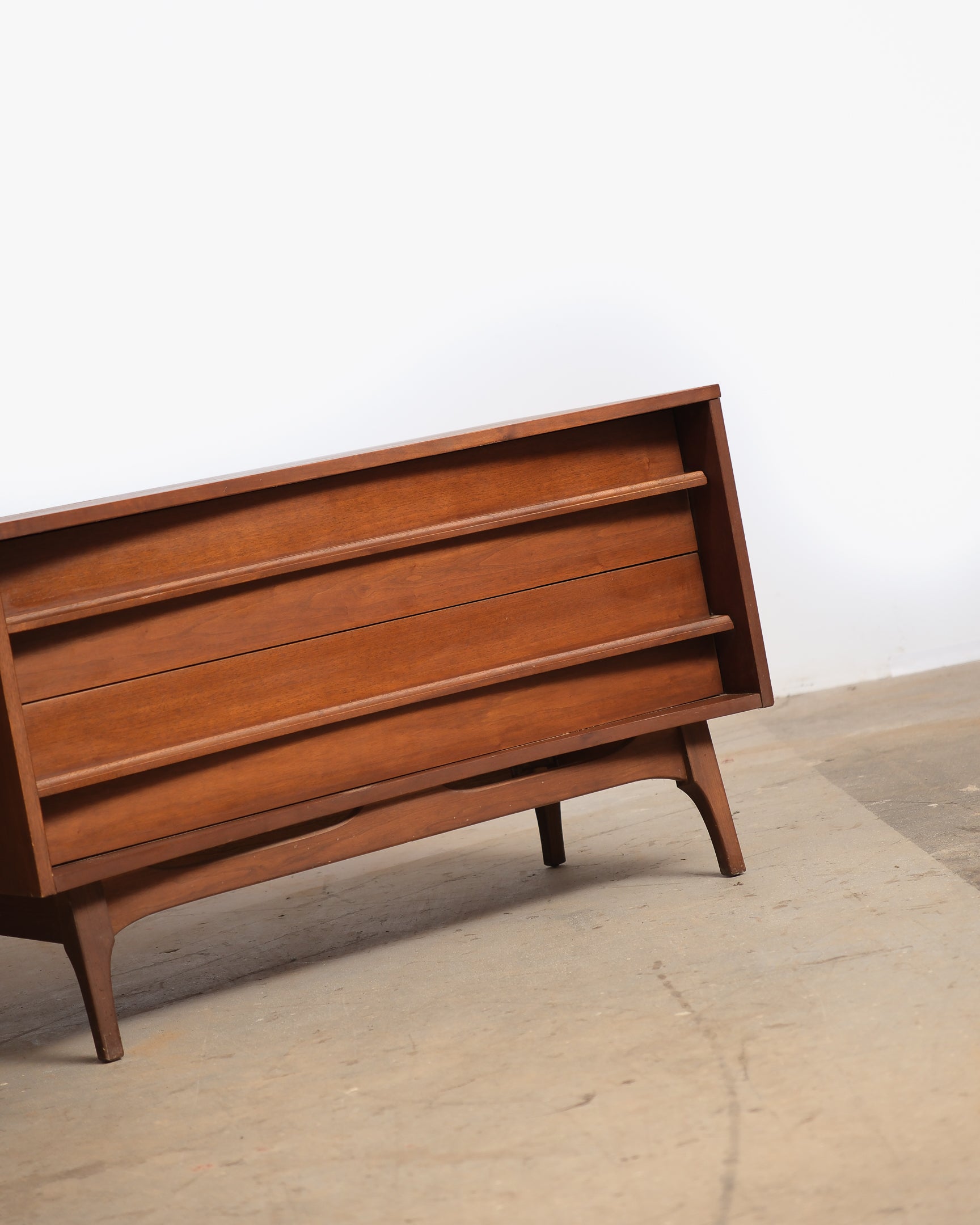 Wooden dresser with a minimalist design on a plain background