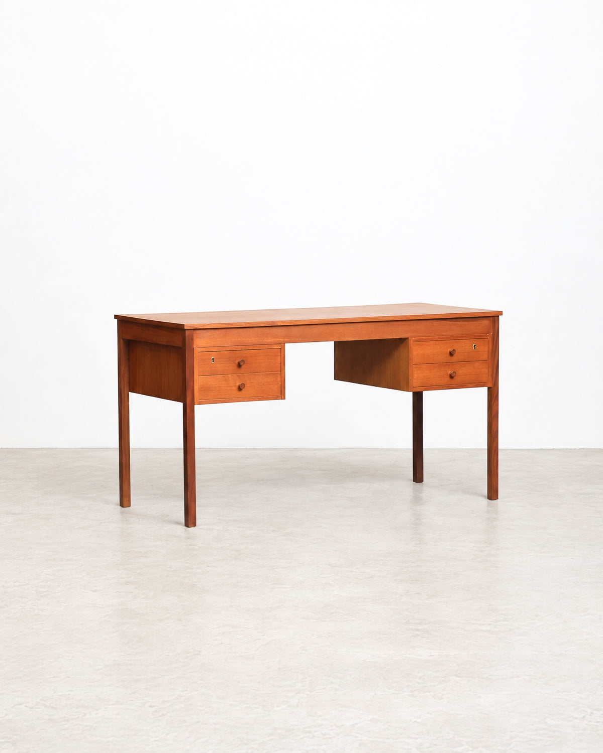 Additional angle of the teak desk showing the full top surface and drawer placement.