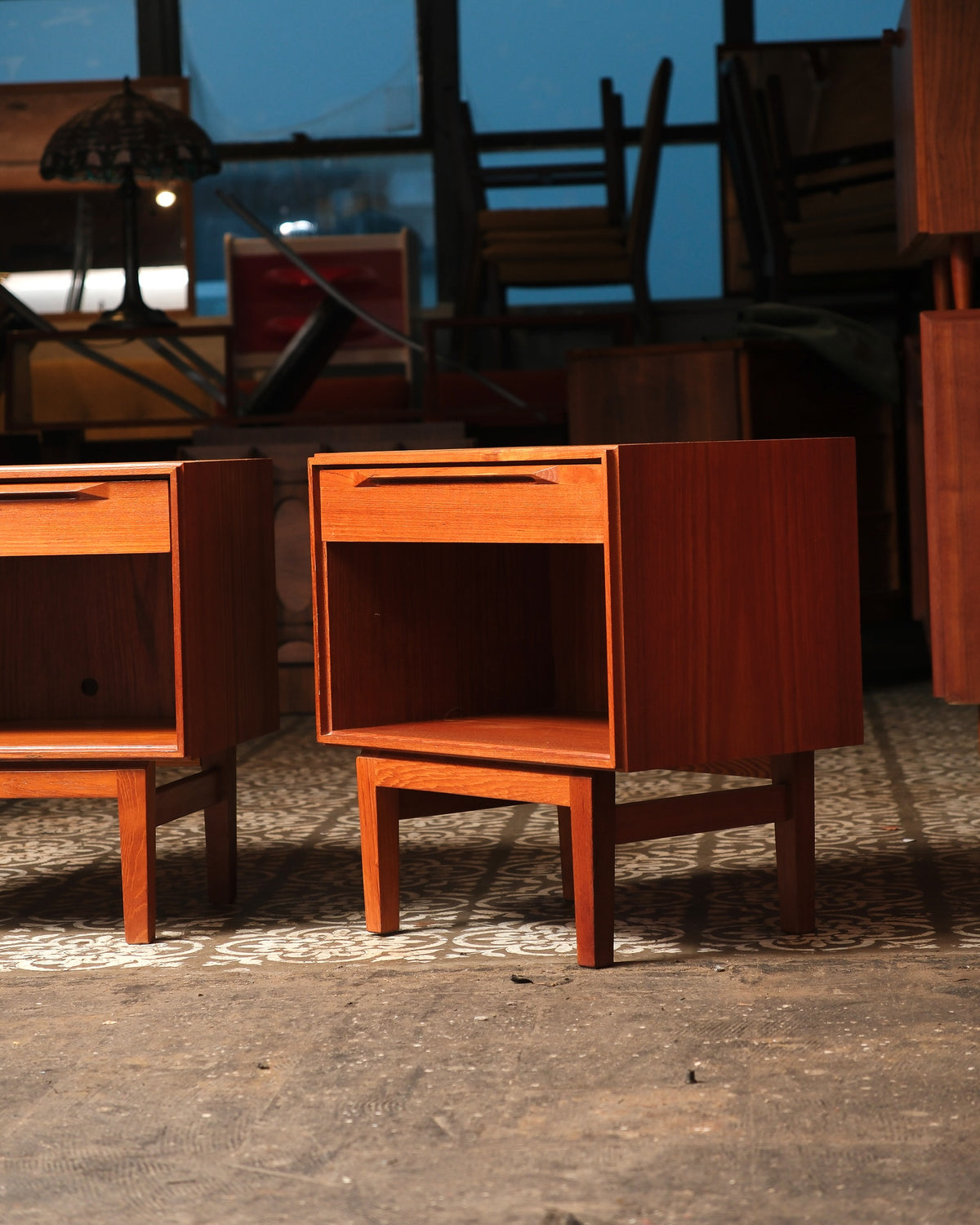 Angled view of both teak nightstands showing drawer, open shelf, and tapered legs