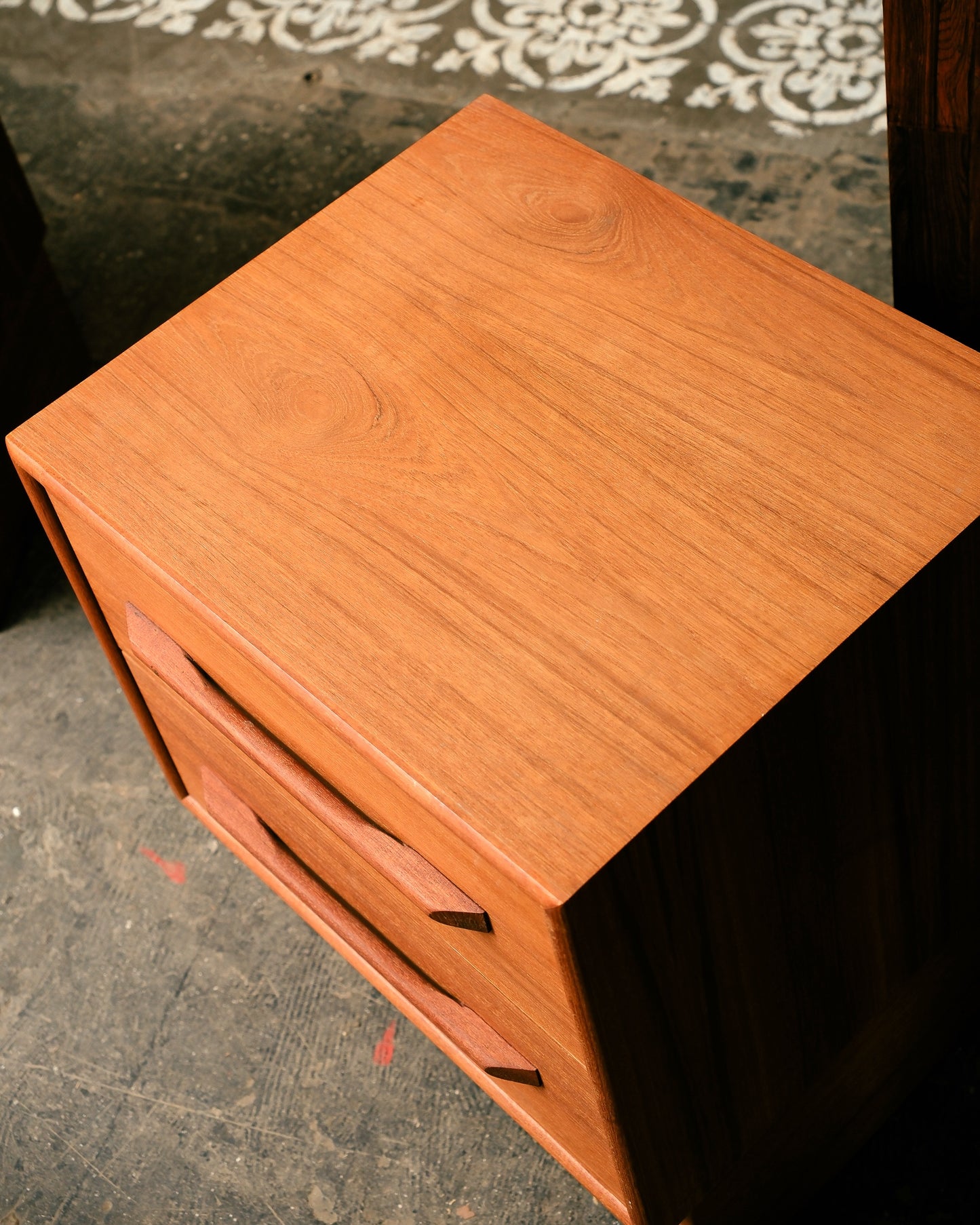 Wooden side table with a drawer on a dark surface