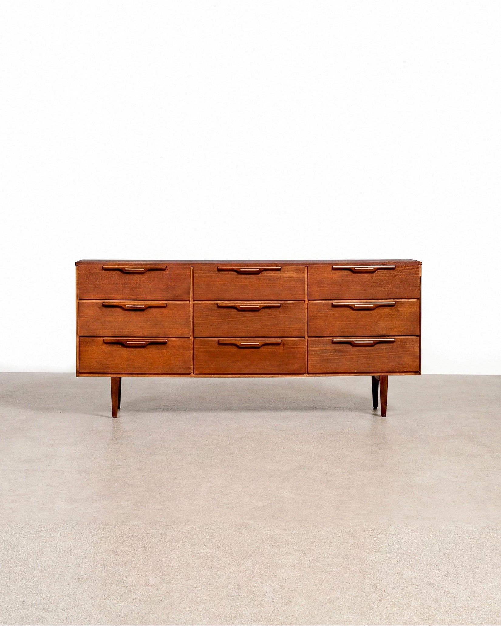 Wooden dresser with multiple drawers on a plain background