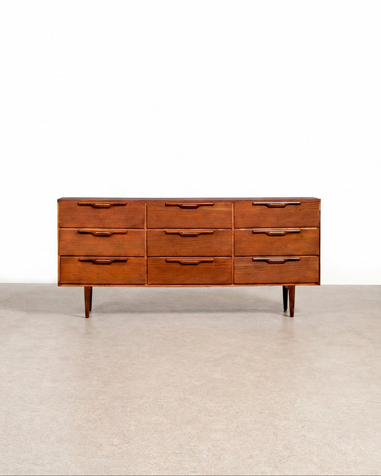Wooden dresser with multiple drawers on a plain background