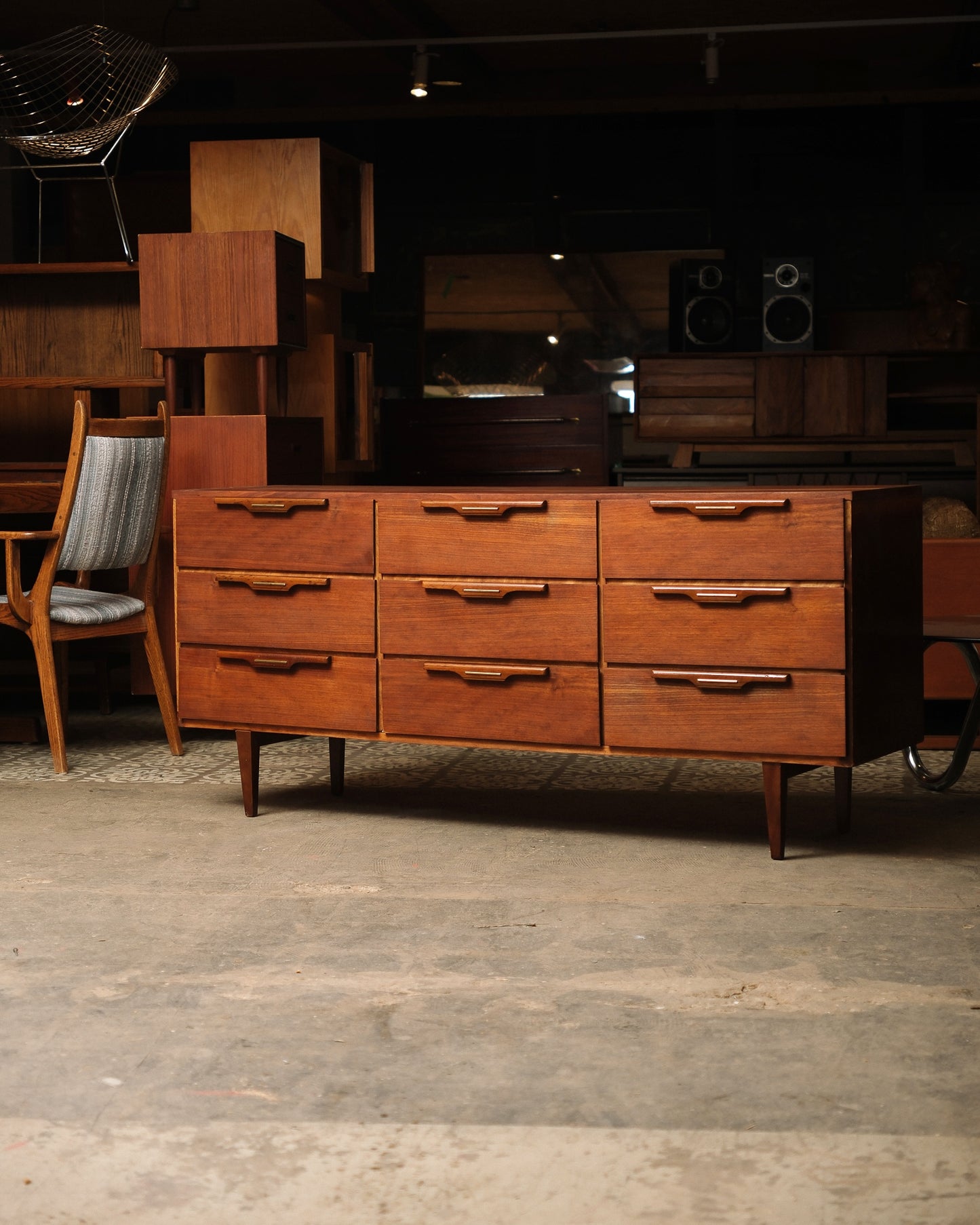 Wooden dresser with multiple drawers in a room with wooden floor and furniture.