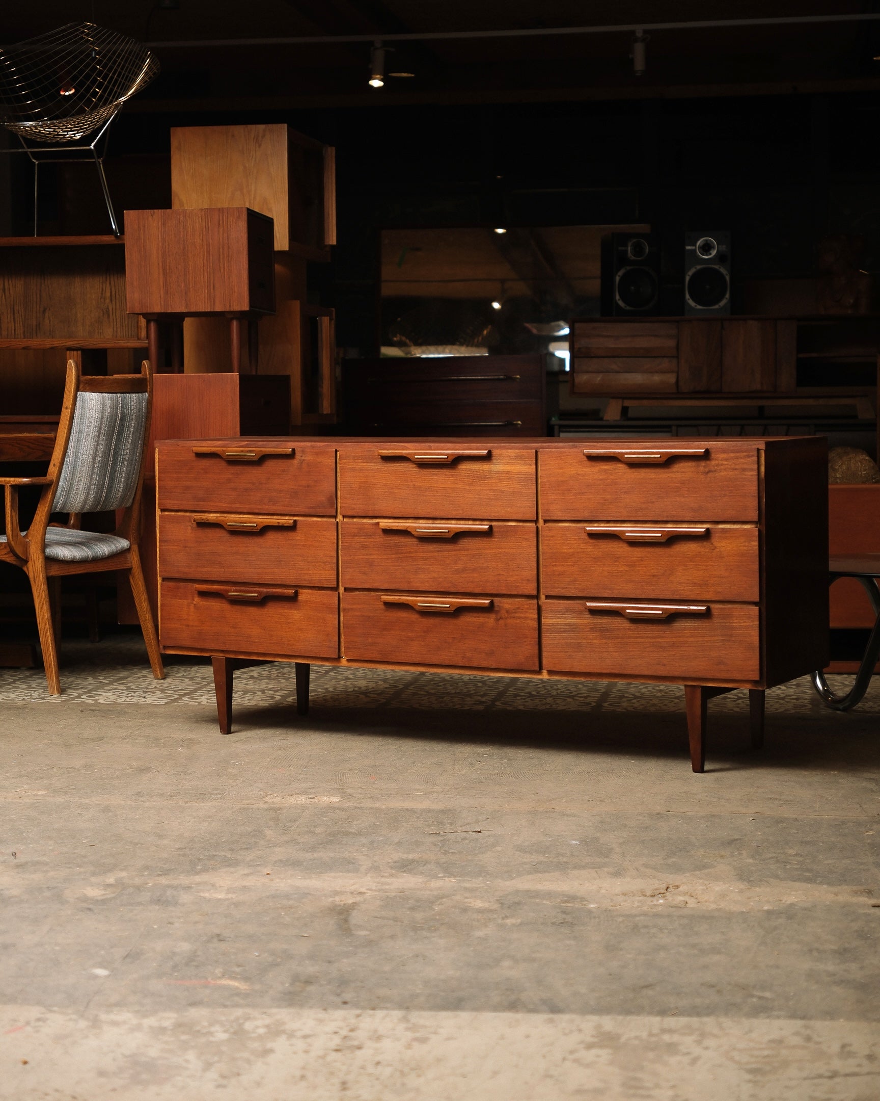 Wooden dresser with multiple drawers in a room with wooden floor and furniture.
