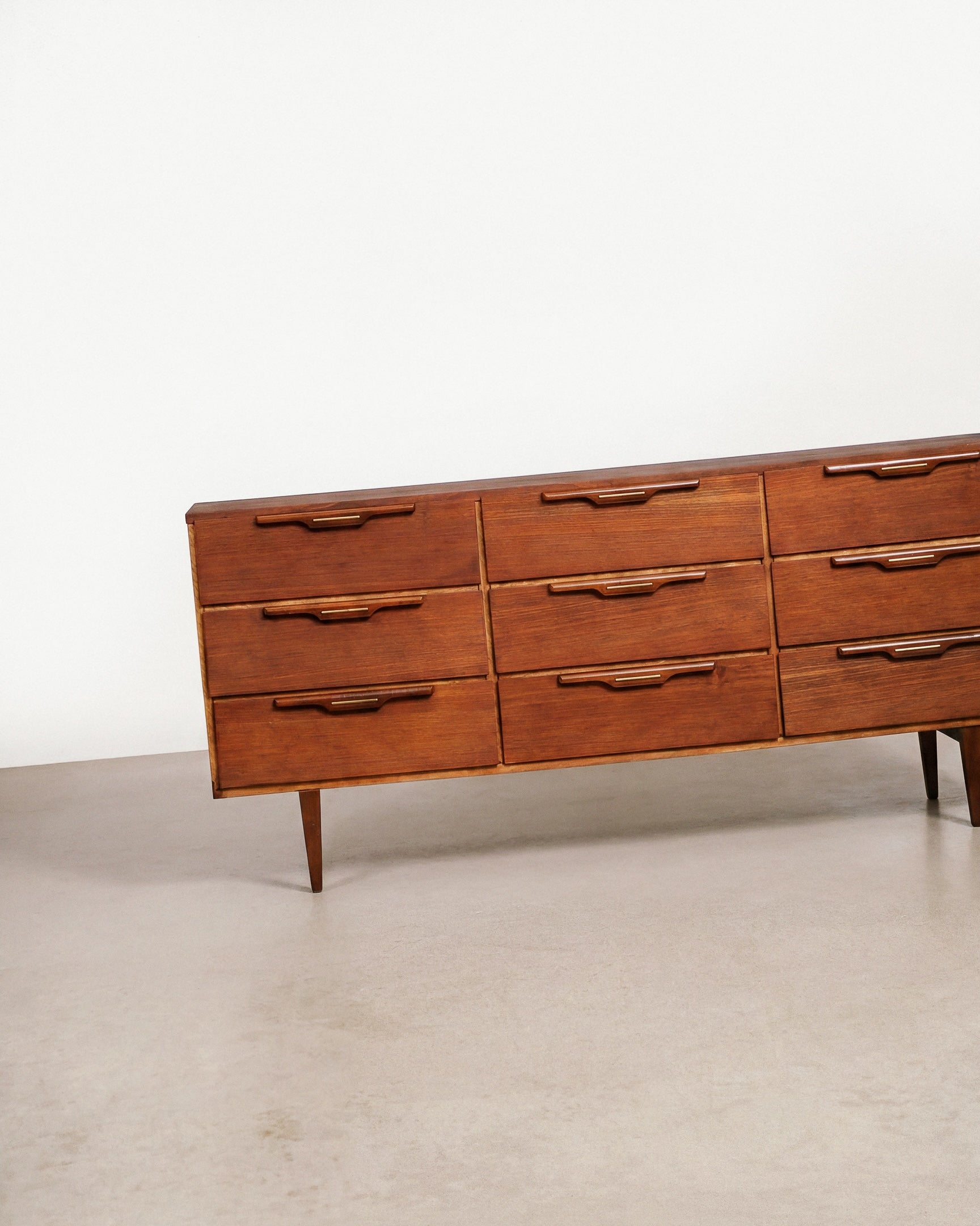 Wooden dresser with multiple drawers on a plain background