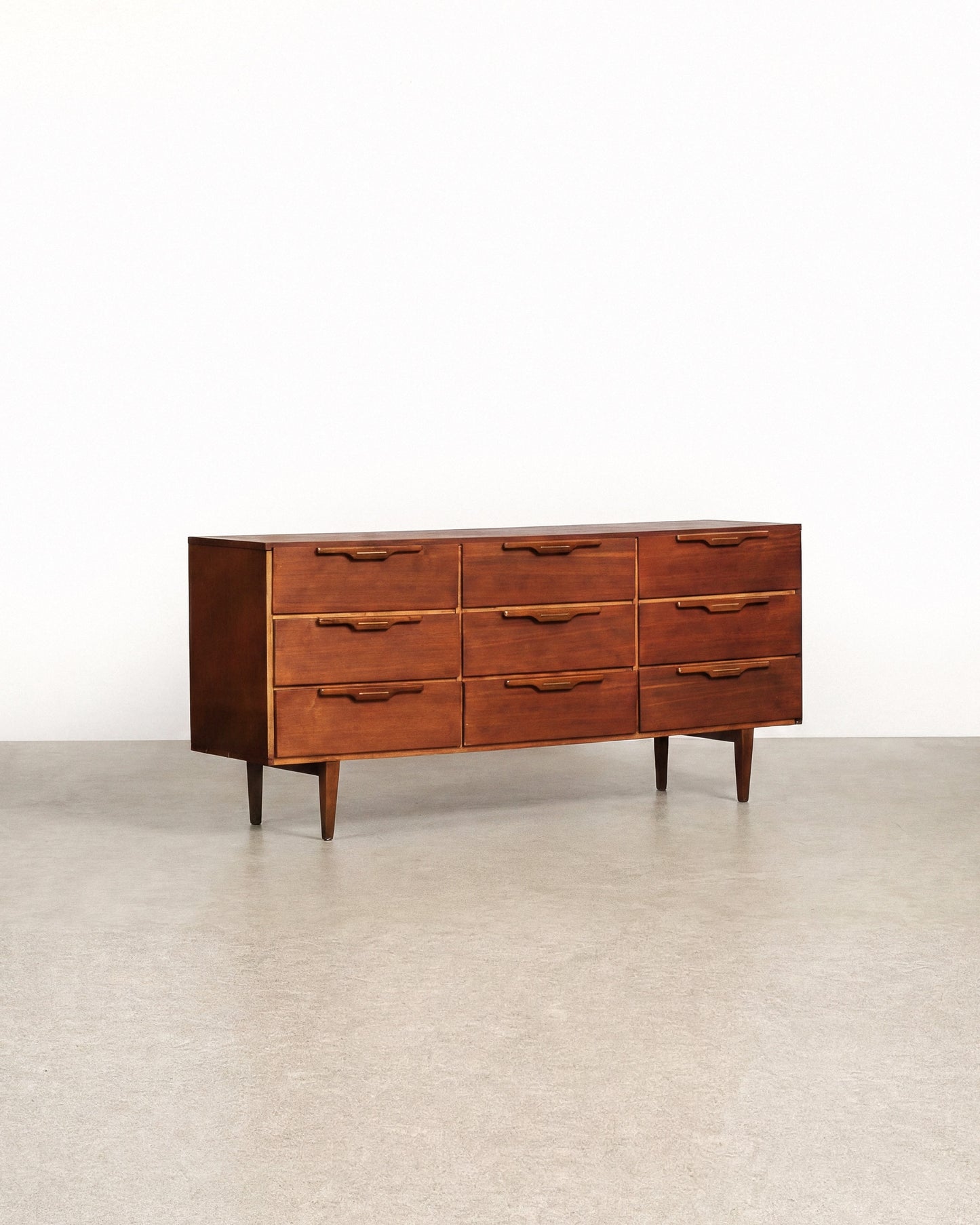 Wooden dresser with multiple drawers on a plain background