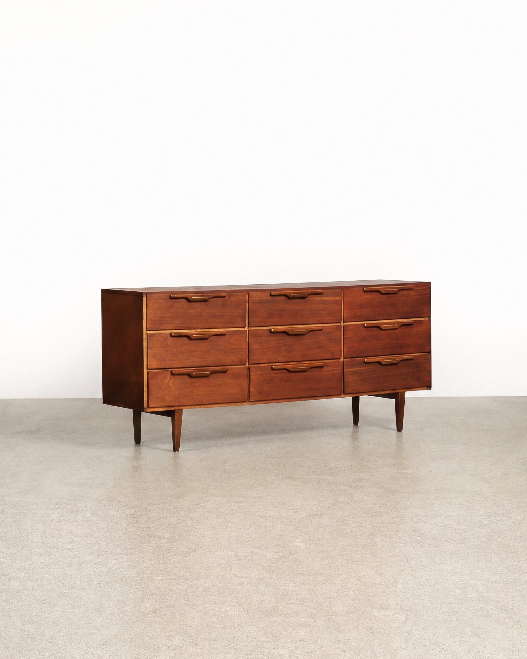 Wooden dresser with multiple drawers on a plain background