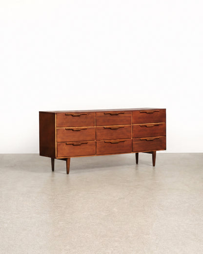 Wooden dresser with multiple drawers on a plain background
