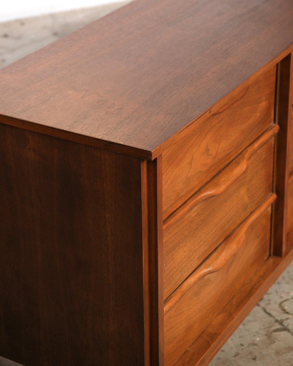 Close-up of the top corner and drawer front detail showing walnut grain and joinery