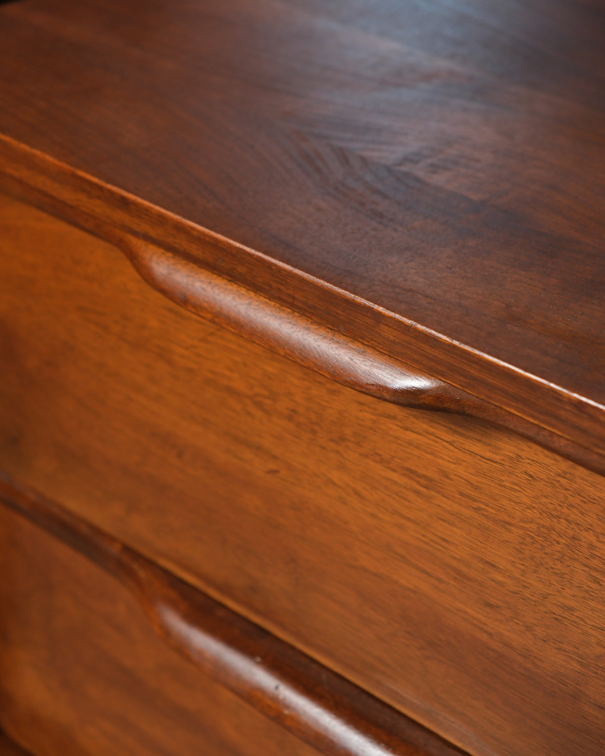 Close-up detail of the sculpted drawer pull and top edge joinery.