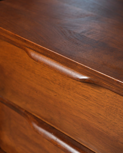 Close-up detail of the sculpted drawer pull and top edge joinery.