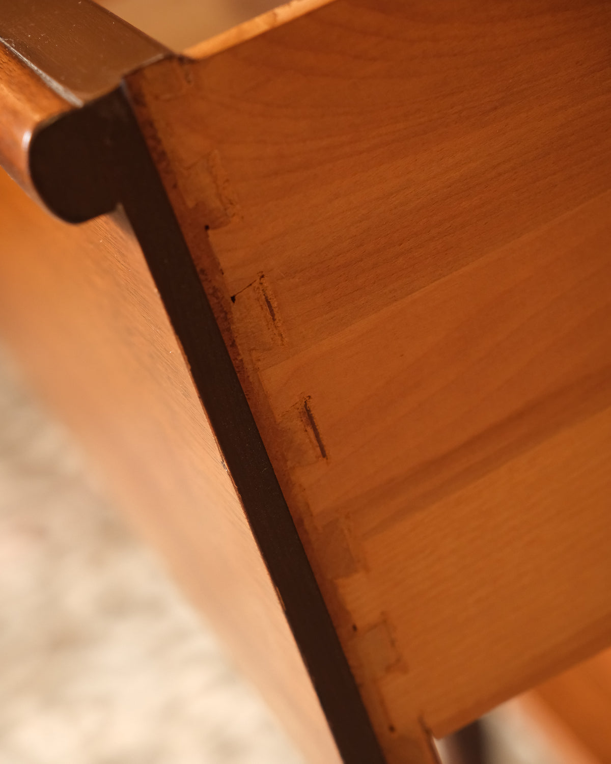 Interior view of a drawer showing dovetail joints and unfinished wood.
