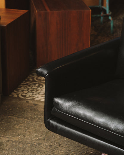 Close-up of the leather armrest and seat cushion showing texture and stitching detail.