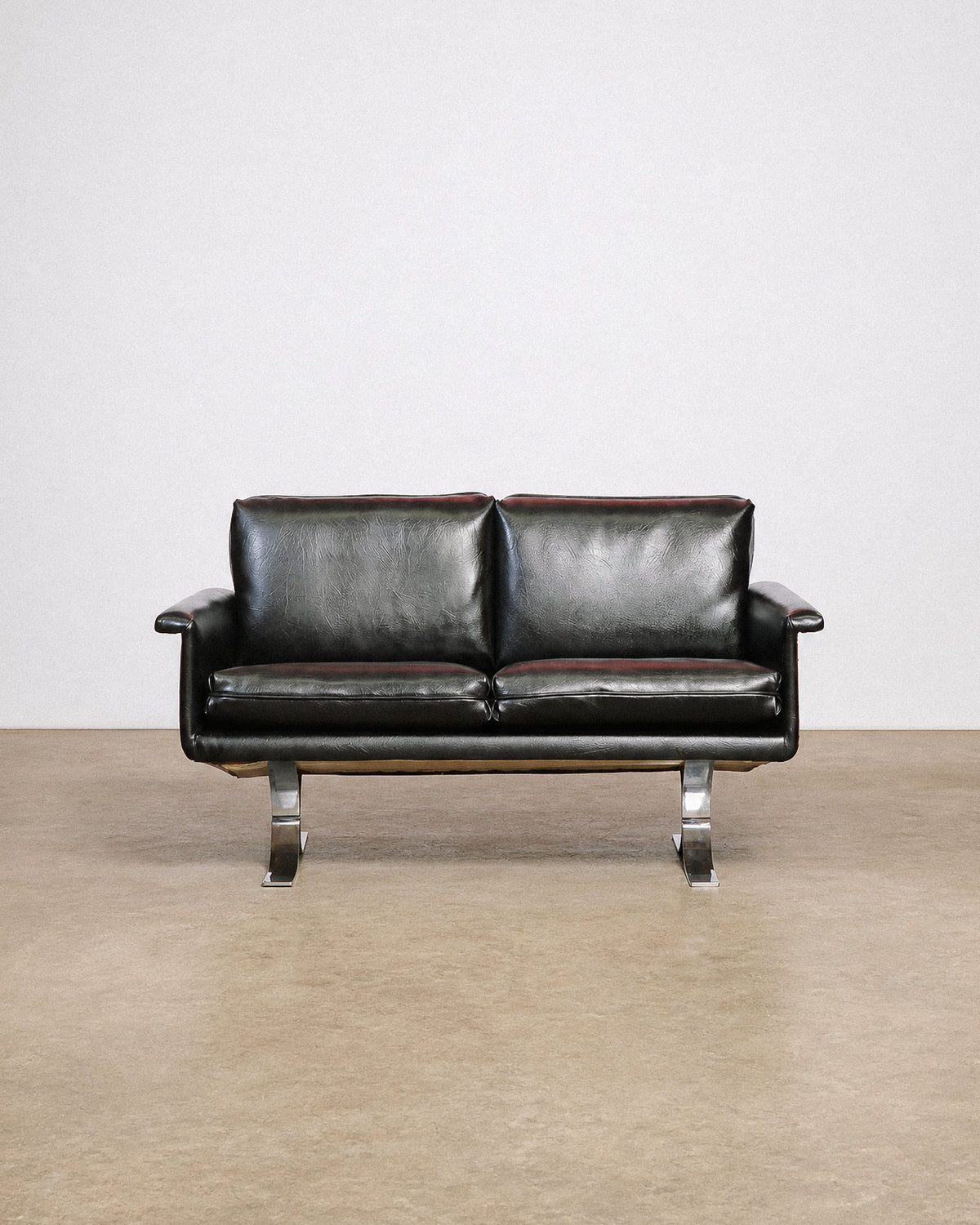 Back view of the sofa showing the leather upholstery and frame construction.