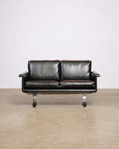 Back view of the sofa showing the leather upholstery and frame construction.