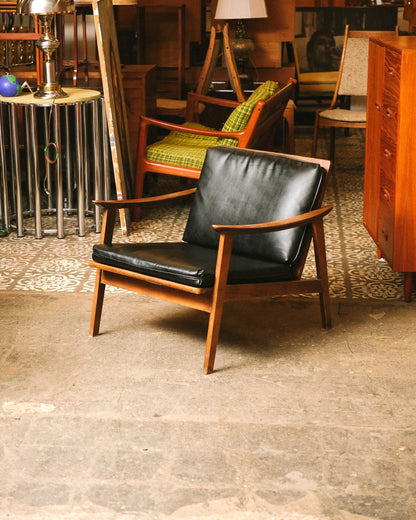 Front angled view of the lounge chair on patterned floor tile, showing full frame and cushions.