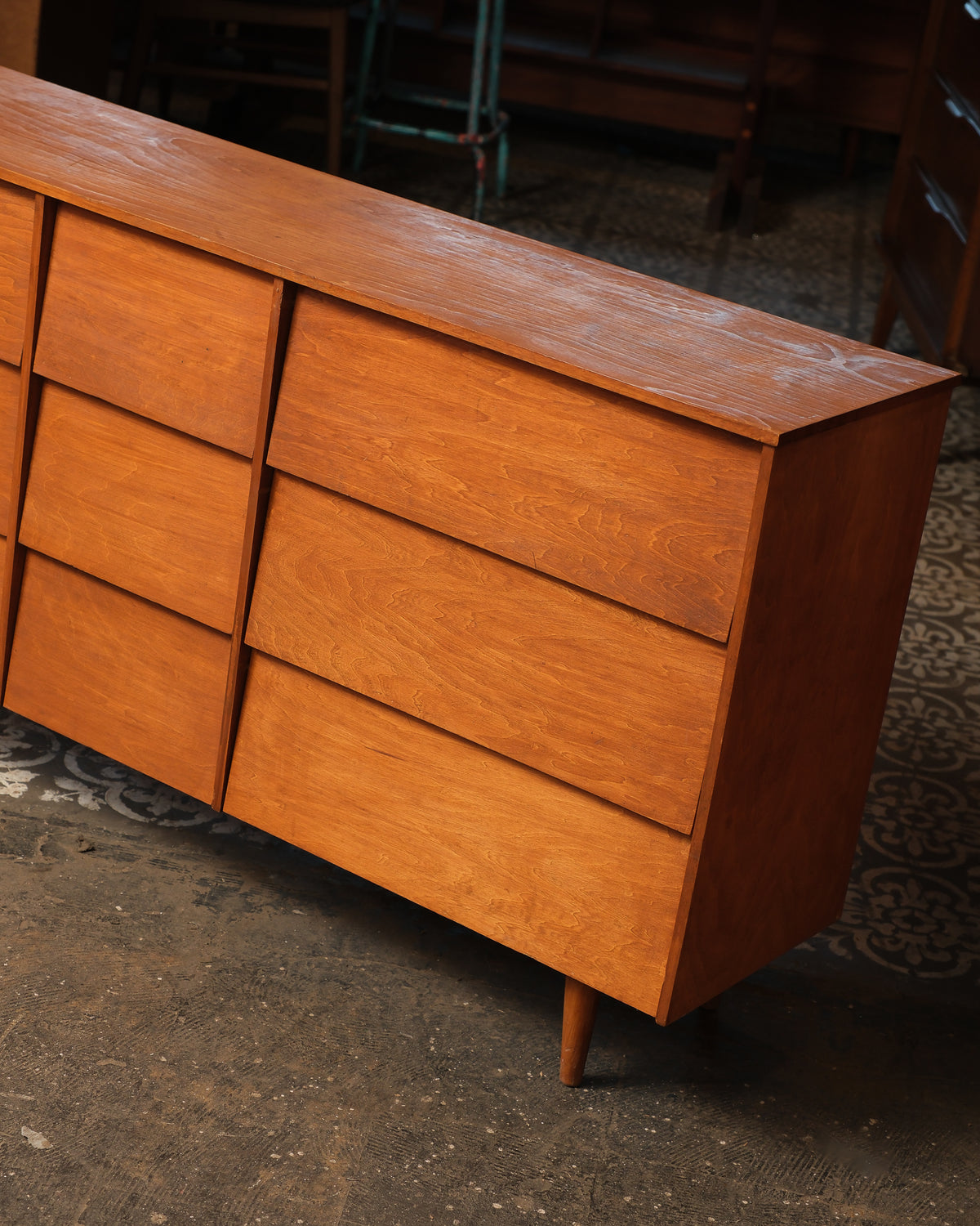 Close-up angled view of the dresser's right side showing drawer fronts and tapered leg.