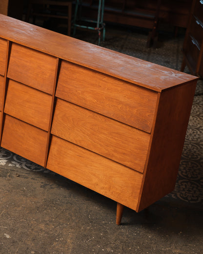 Close-up angled view of the dresser's right side showing drawer fronts and tapered leg.
