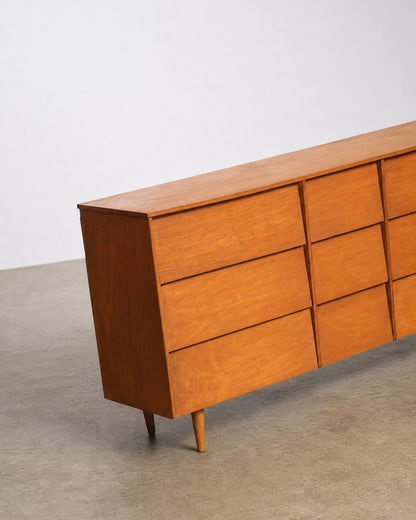 Close-up angled view of the dresser's top and side in a studio setting.