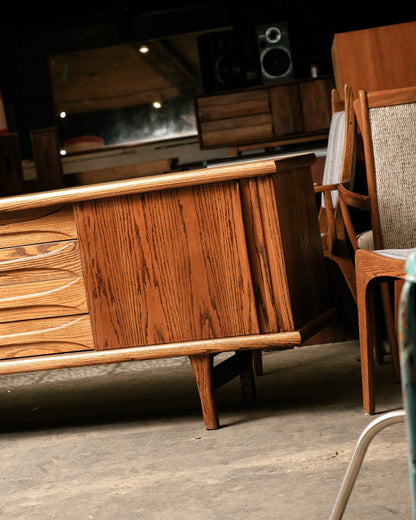 Wooden cabinet with a chair and television in the background