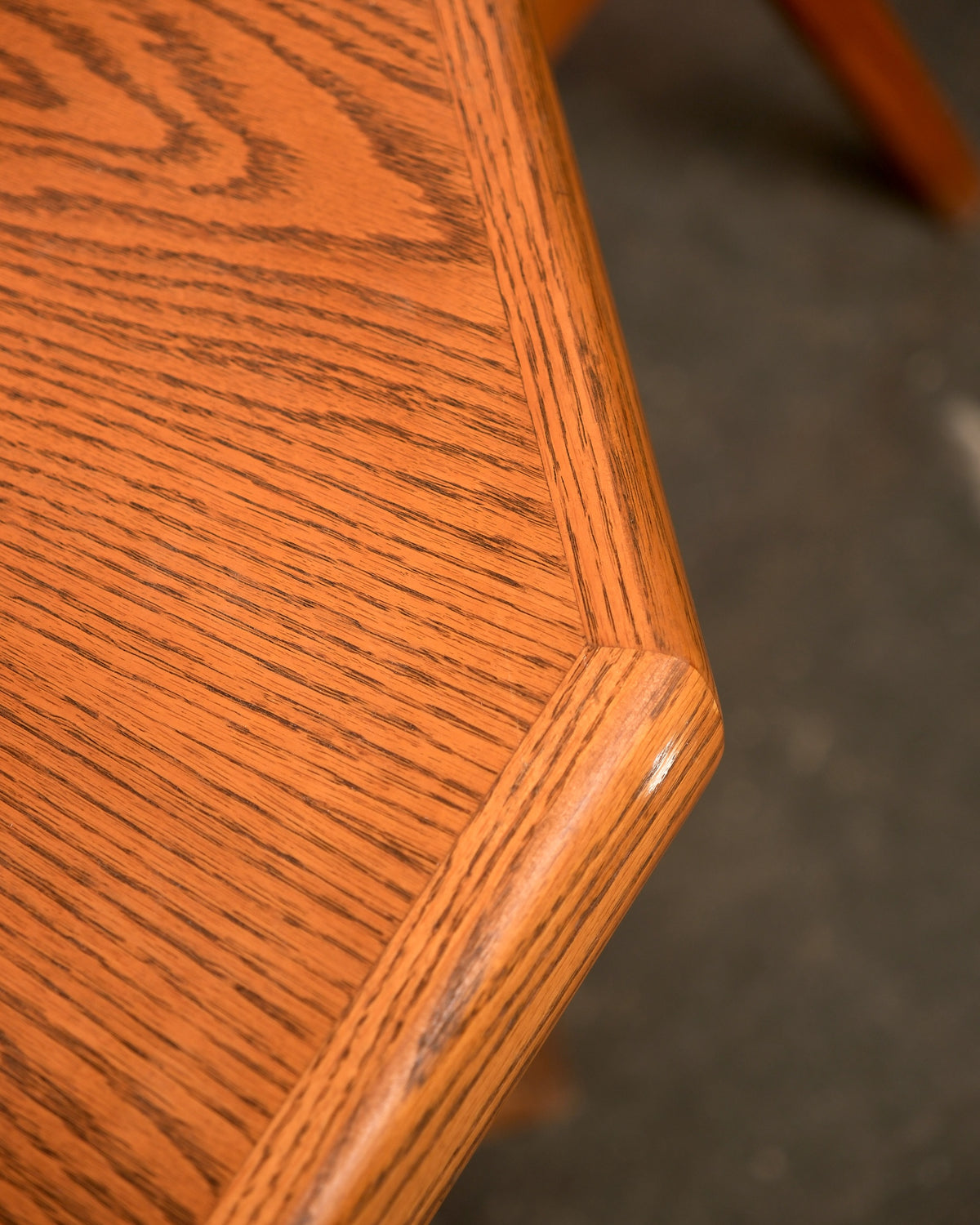 Close-up of the octagonal oak table top corner showing grain and joinery detail.