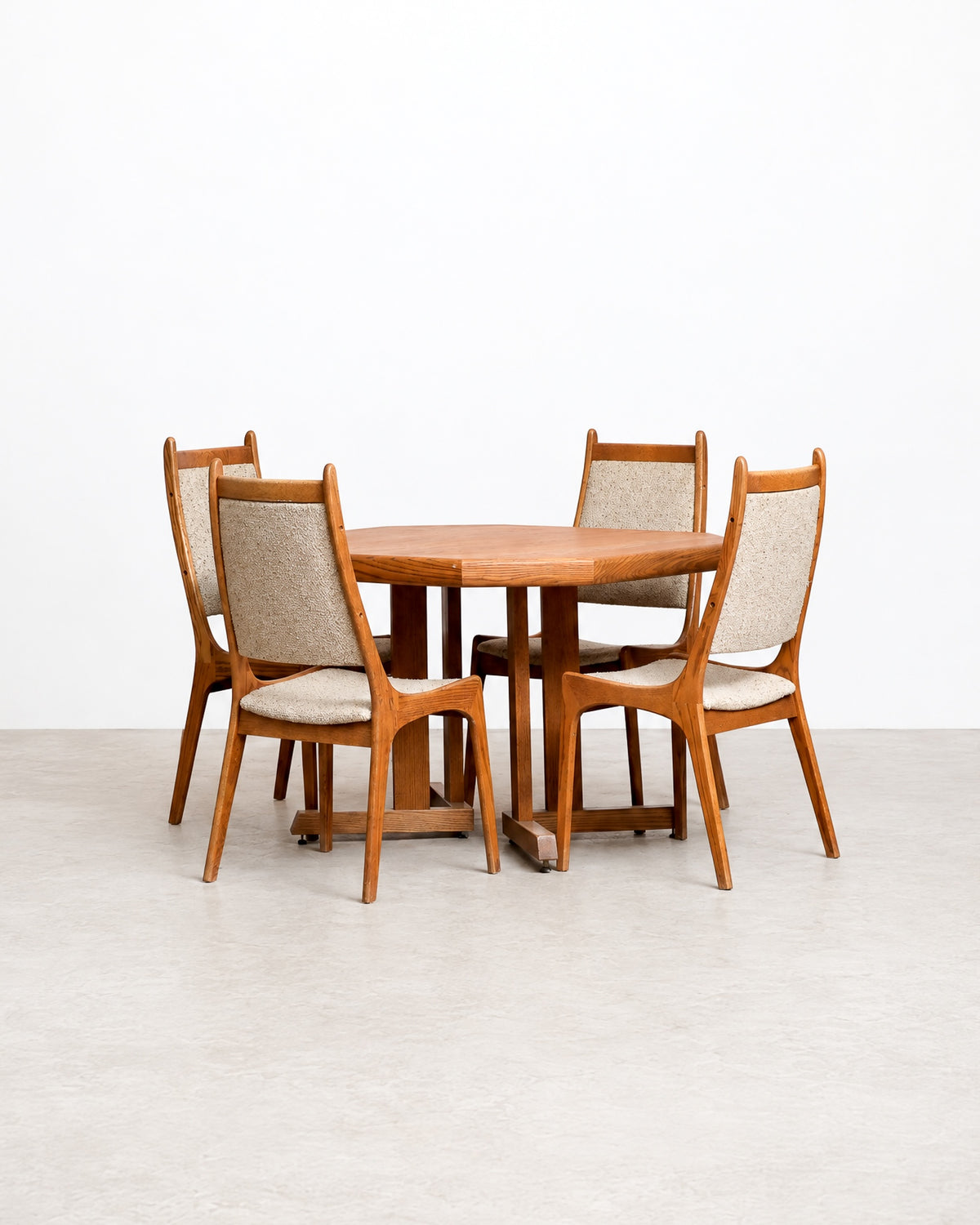 Mid-century modern oak extendable dining table with four upholstered chairs, front view.