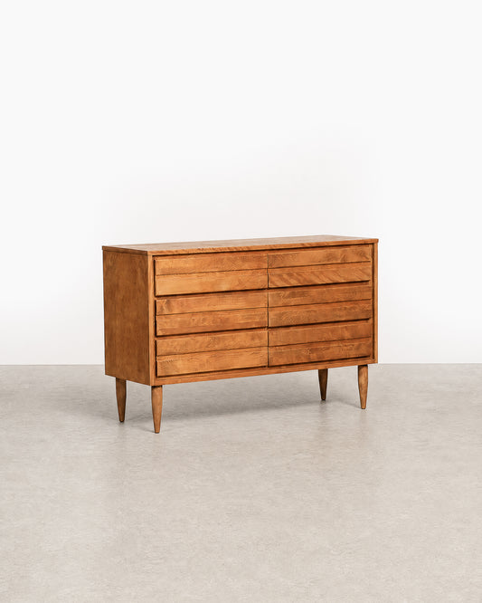 Wooden dresser with multiple drawers on a plain background