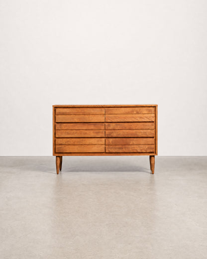 Wooden dresser with six drawers on a plain background