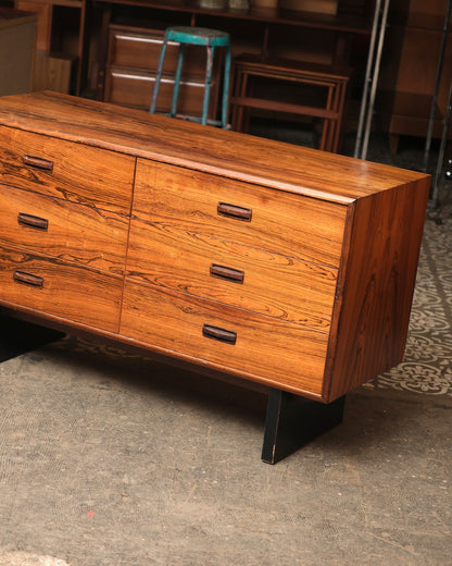 Close angled view of the rosewood dresser showing drawer fronts, wood pulls, and top corner joinery.
